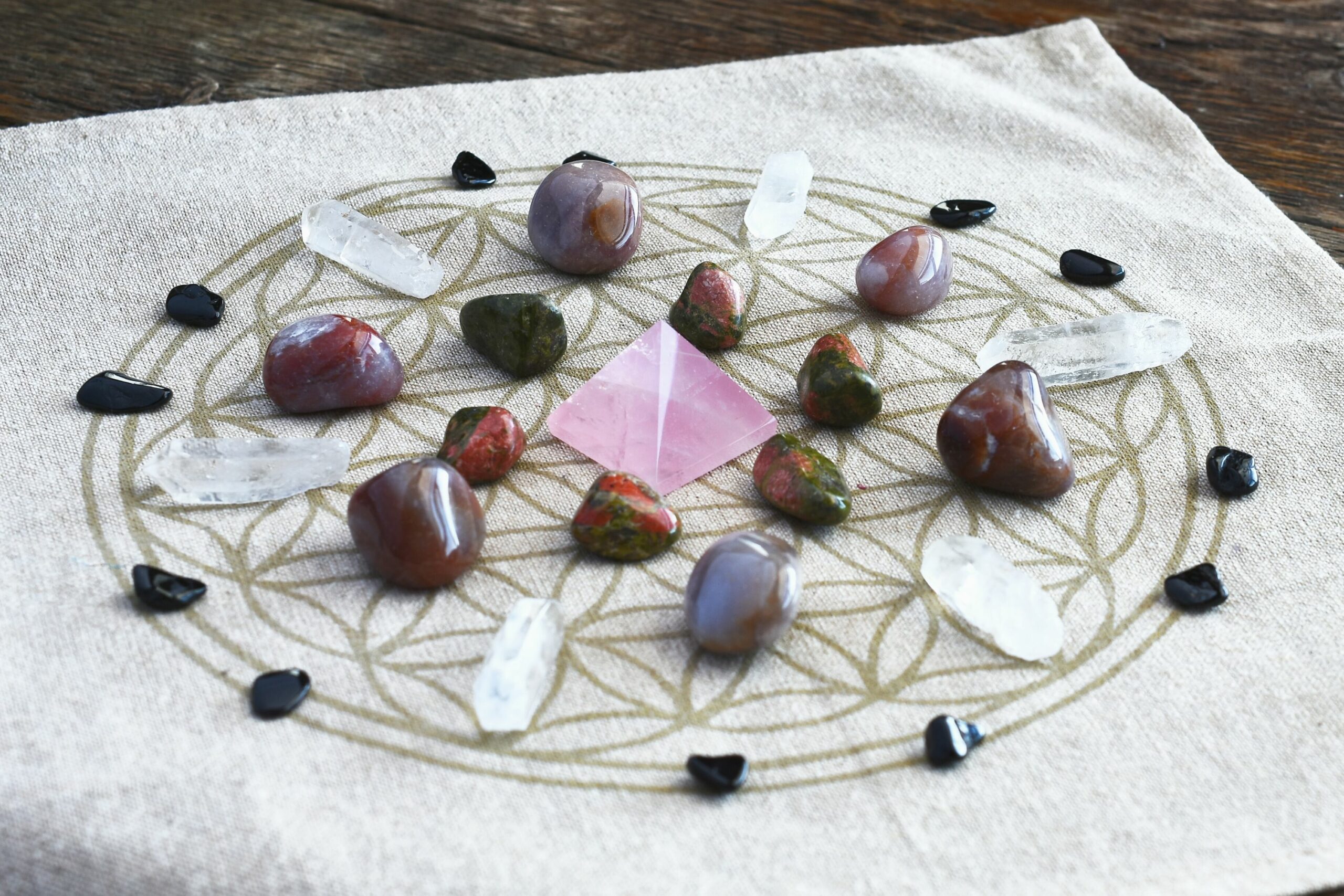 Crystals arranged in a geometric crystal grid on a canvas cloth with flower of life pattern
